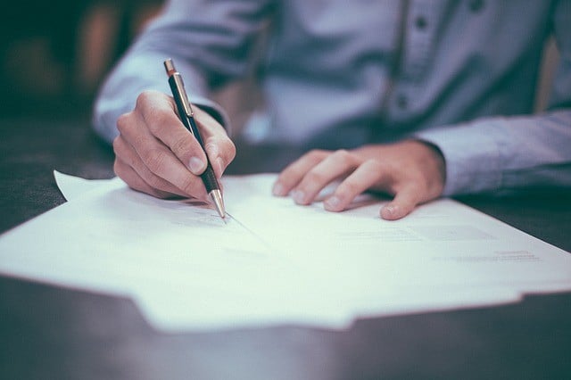 A person signing their binding estimate.