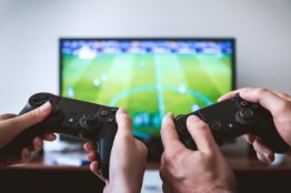 Two people playing football on TV