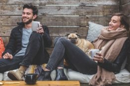 A man and a woman sitting and laughing.