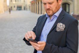 A man in a suit holding a phone.