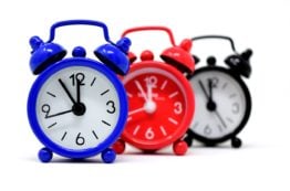 Three alarm clocks lined up.