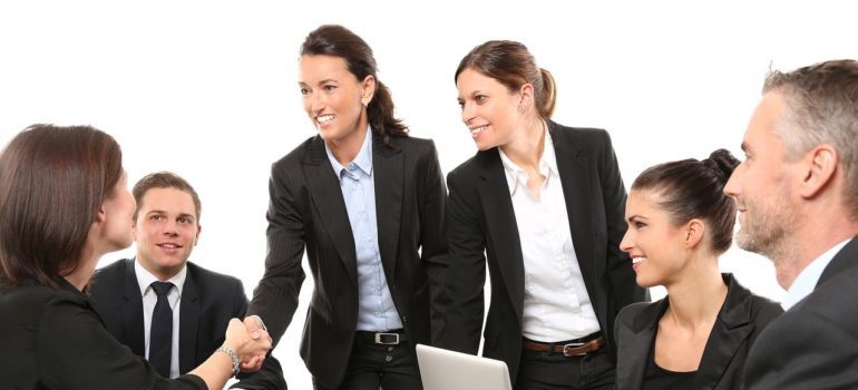 Colleagues shaking hands before moving offices overseas.