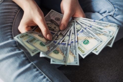 A woman holding money - here's how to get the most affordable moving solutions