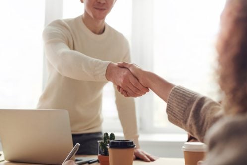 A man and a woman shaking hands - here's how employers can help you relocate