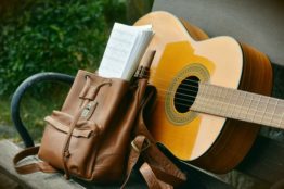Brown acoustic guitar and a brown backpack