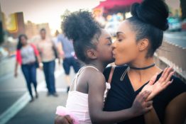 A mother carrying her daughter and kissing her
