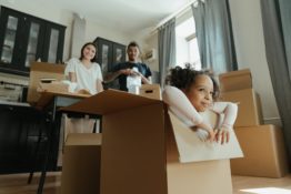 Parents watching a kid playing inside a moving box