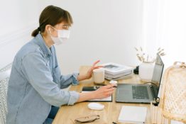 Woman with a mask working in an office in 2020