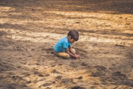 A kid playing in sand