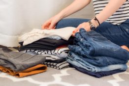 Woman folding clothes to declutter for a green relocation to Chelsea