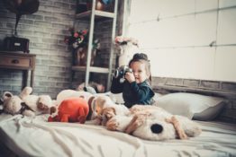 kid on bed with toys