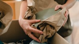 a woman wrapping plates in paper