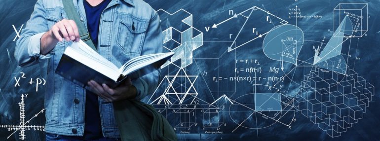 Teacher with the book and the board with some calculations on it.