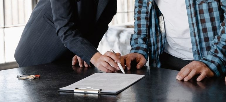 sign contract a woman showing notes to a man in order to find a perfect co-op in Queens