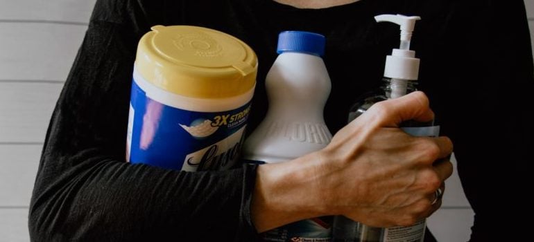woman holding cleaning supplies in order to prepare your Manhattan storage unit for fall