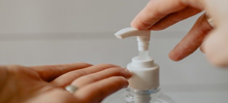 a person applying hand sanitizer - moving safely in NYC during COVID-19 restrictions is very important