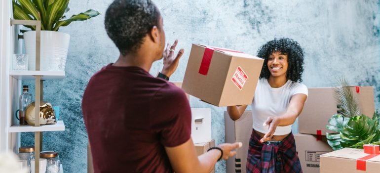 A woman throwing a box to a man