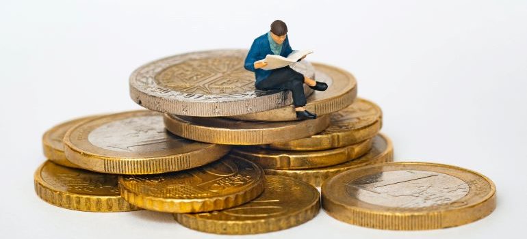 man figurine sitting on coins trying to figure out which storage is best for your needs