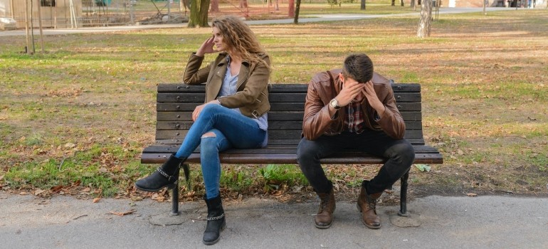 a couple sitting on a bench thinking of moving out of your Brooklyn apartment after breakup