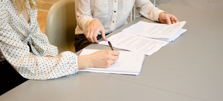 Two women discussing about relocating your company to smaller premises
