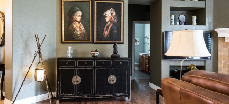 The two paintings on the wall above the drawer.
