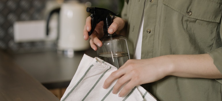 person holding cleaning supplies