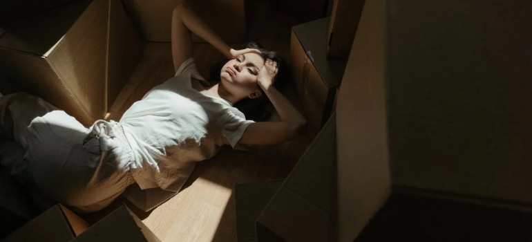 a woman lying on the floor surrounded by boxes